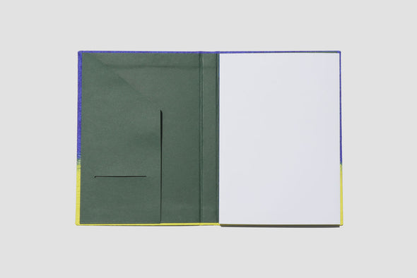 Inside cover of Gugimfolio Notebook Folio Blue and Yellow which features a green inside sleeve, with holder for papers and a business card