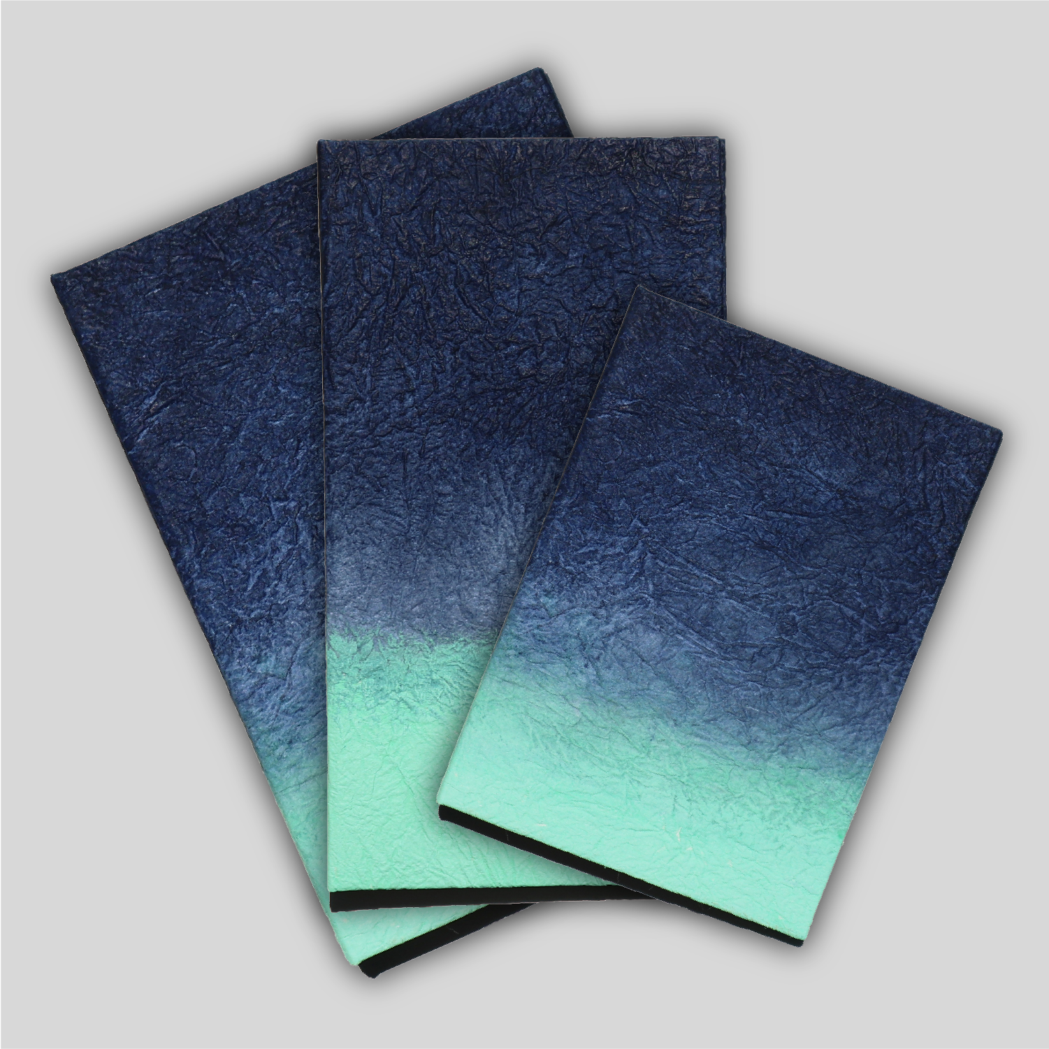 Fanned array of Gugimfolios in A5, Travel, and A6 in Navy/Mint